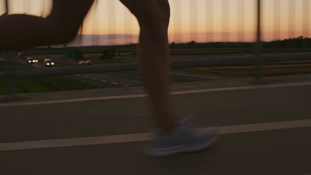 一个女人的腿在黄昏跑过一座桥视频下载