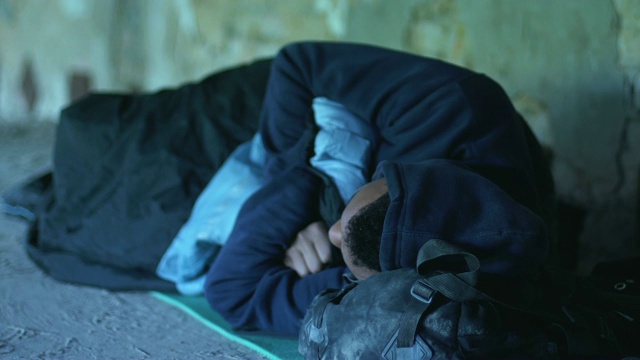 无家可归的美国黑人男孩睡在地下通道，痛苦和贫穷视频素材