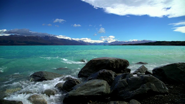 泰卡波湖在新西兰的岩石海滩上波涛汹涌视频下载