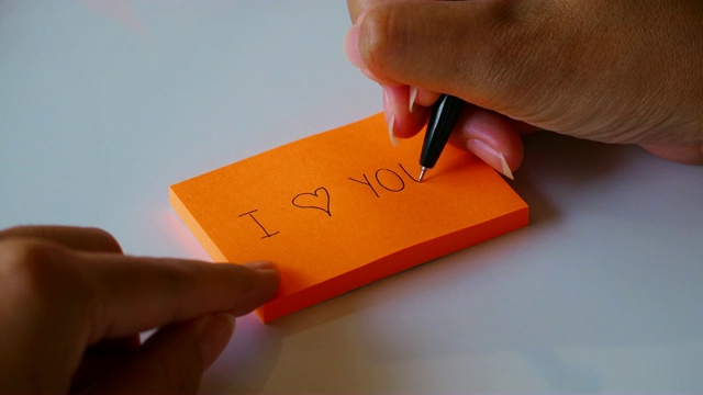 把“我爱你”写在橙色的便条纸或记事本上视频下载
