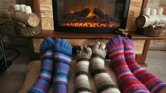 脚上穿着滑稽的羊毛袜子，在圣诞节时被温暖的炉火温暖视频下载