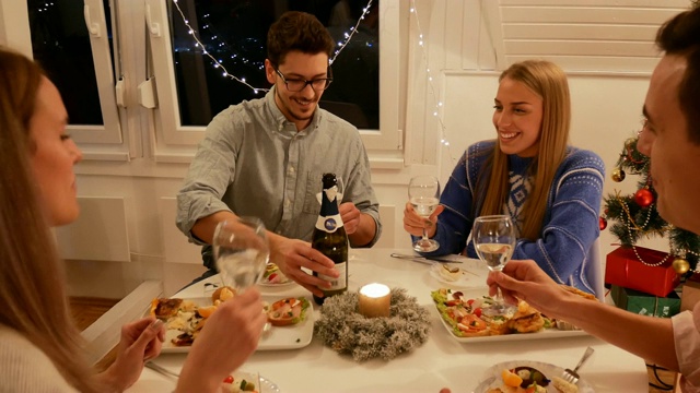 圣诞晚餐——Z世代庆祝圣诞节，并享用香槟晚餐视频素材