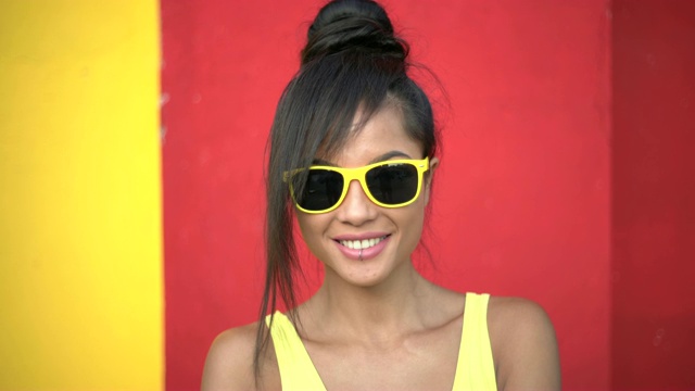 美丽的年轻女子站在黄色和红色的背景视频素材