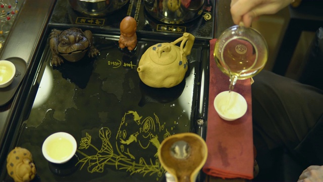茶道。师傅将绿茶从玻璃茶壶中倒入白色杯子中视频素材
