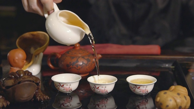 茶道。师傅将茶倒在白色杯子上视频素材