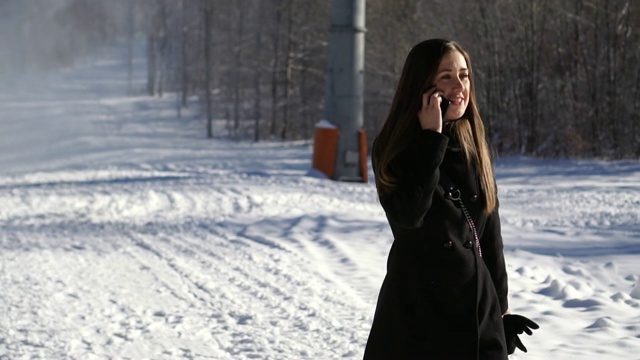年轻的女孩在雪地里边走边讲电话——慢悠悠的莫视频下载