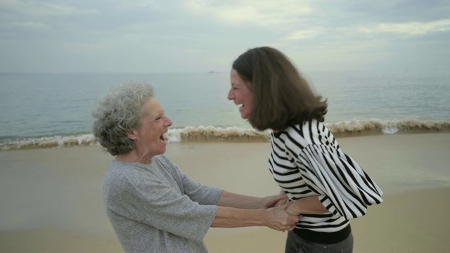 年长的母亲和成年的女儿在海边的海滩上拥抱视频下载