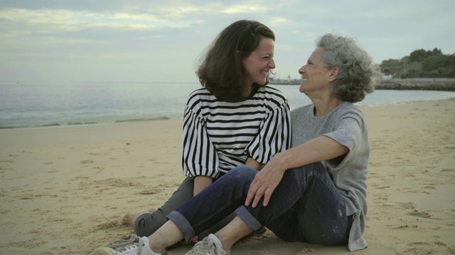 年长的母亲和快乐的女儿在海滩上碰鼻子视频下载