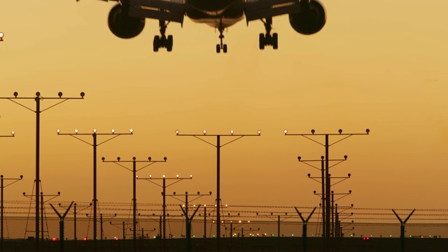 日落时分，一架飞机降落在美国洛杉矶的跑道上视频素材