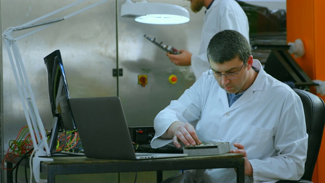 男性机器人工程师在4k桌检查电路板视频下载