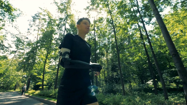 一个青少年用假手进行慢跑训练。未来的半机械人概念。视频下载