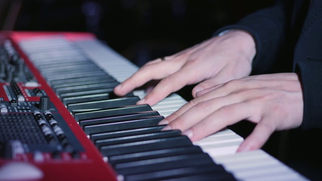 在键盘合成器上弹奏钢琴琴键的音乐家视频素材