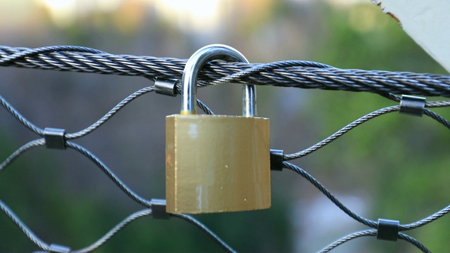 挂锁附在网格上。爱情锁系在桥上视频下载