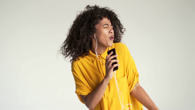 一名非洲裔美国女性一边在手机上听音乐一边唱歌视频素材