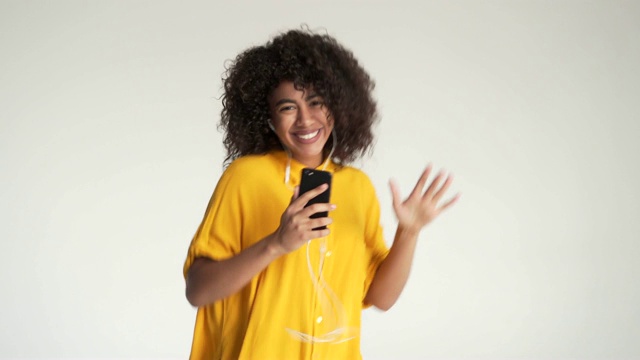 非洲裔美国妇女一边戴着耳机听音乐一边跳舞视频素材