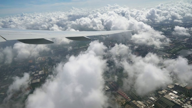 从飞机上飞过云层俯瞰城市的景象视频下载