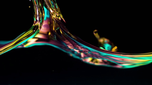 水波和气泡在水箱中以发光的颜色照亮，黑色背景，慢动作视频下载