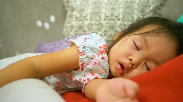 亚洲小女孩睡在床上。视频下载