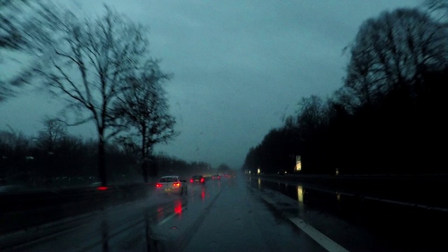 在欧洲德国的高速公路上，在雨中驾车穿过一片漆黑的森林视频下载