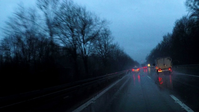 在冬天的夜晚，在雨中驾车穿过一片黑暗的森林，德国，欧洲视频下载