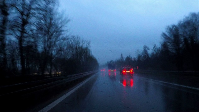 在冬天的夜晚，在雨中驾车穿过一片黑暗的森林，德国，欧洲视频下载