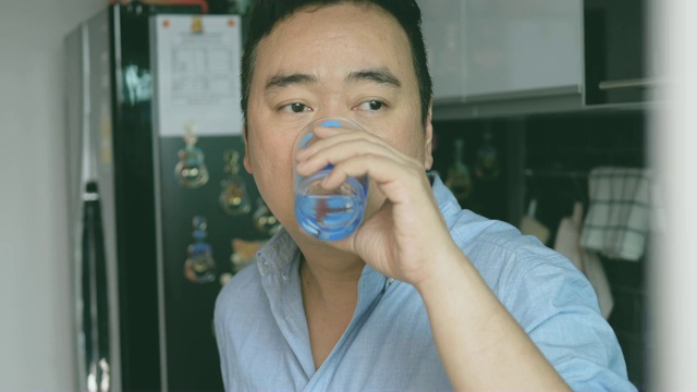 年轻男子从玻璃杯里喝水的肖像视频素材