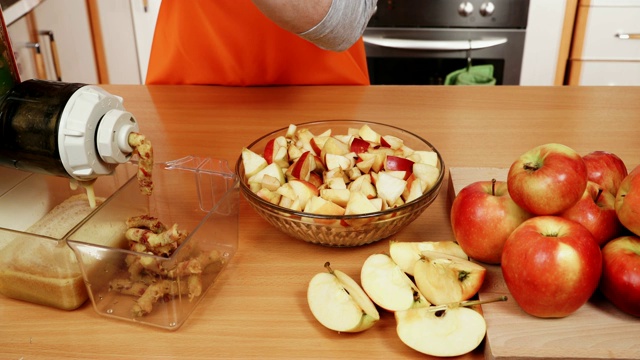 女性双手在榨汁机中添加苹果果实4K视频素材