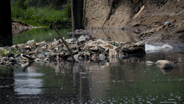 图中显示的受污染和起泡的Citarum河部分据报道正遭受染料和其他化学品倾倒到河里的影响，印度尼西亚。视频下载