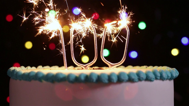 蛋糕庆祝100岁生日与数字形状的火花在慢动作拍摄视频下载