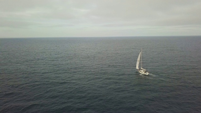 白帆游艇航行在蓝海和多云的天空景观无人机视图视频素材