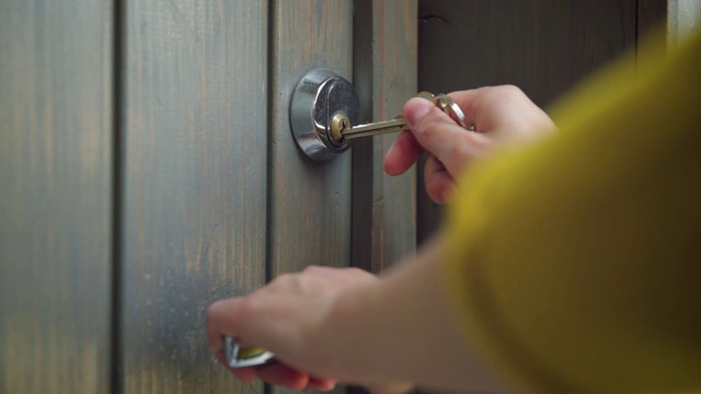 女人用钥匙打开大门。使用钥匙和锁门的人员。房地产安全概念视频素材