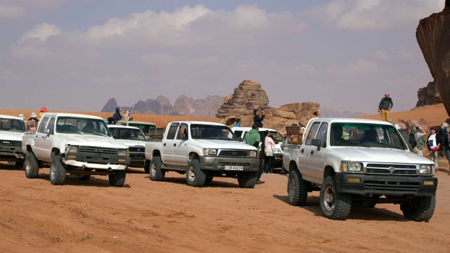 在约旦的瓦迪拉姆沙漠中，大量的游客使用4X4车辆参加沙漠旅行视频下载