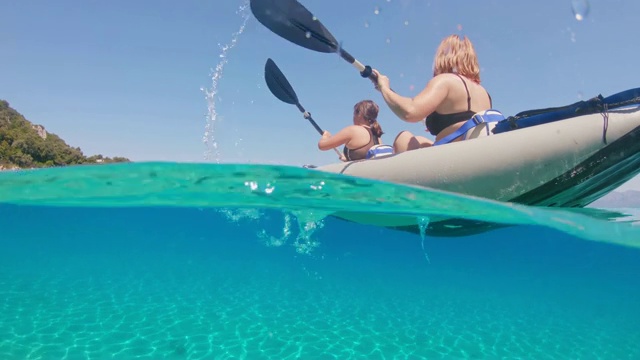 克罗地亚佩列沙茨，母女俩在阳光明媚的碧蓝海洋上划着皮艇视频素材