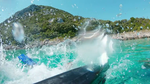 克罗地亚佩列沙茨，一名女子从皮划艇上跳入阳光明媚的蓝绿色海洋视频素材