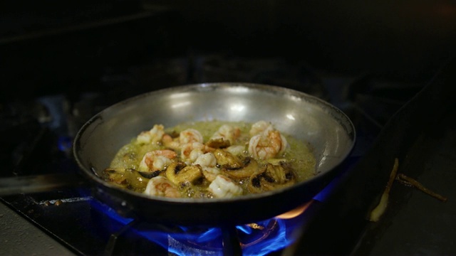 商业厨房油锅里的虾和蘑菇火的慢镜头视频下载