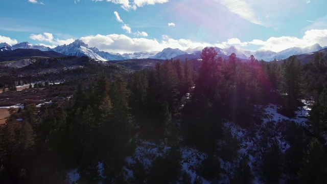 卡车前进的无人机拍摄的森林和雪峰的圣胡安山脉(落基山脉)外特柳赖德，科罗拉多州在一个明亮的，冬天的一天视频下载