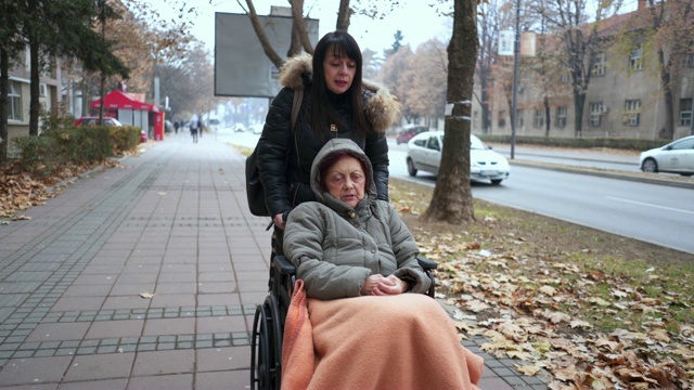 一位坐在轮椅上的老妇人伸出援手视频素材