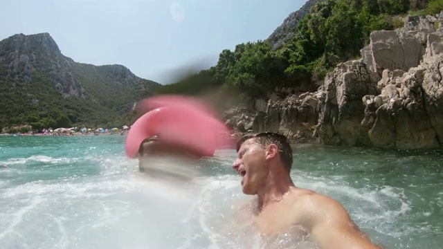 克罗地亚Peljesac，一对夫妇带着可穿戴相机跳入阳光明媚的海洋中视频素材