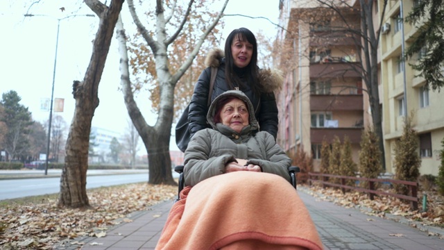一个坐在轮椅上的快乐女人被另一个女人推着视频素材