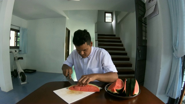 亚洲男子用刀切西瓜视频素材