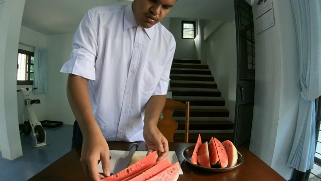 亚洲男子用刀切西瓜视频素材