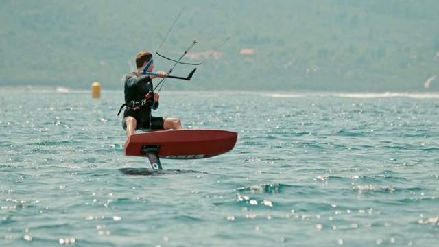 曼在克罗地亚Peljesac阳光明媚的海洋上风筝冲浪视频下载