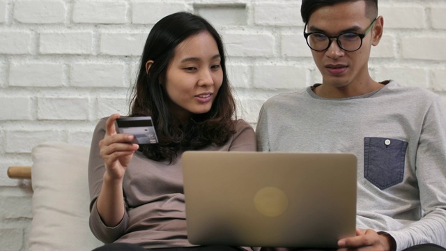 年轻夫妇用信用卡在线购物视频素材