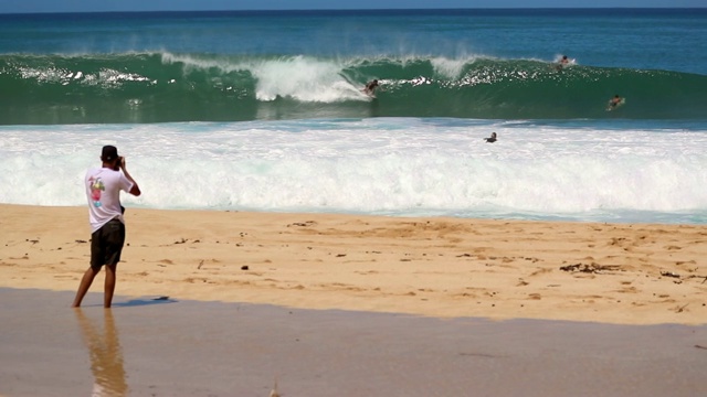 慢镜头男子与相机拍摄的照片冲浪者捕捉波浪在夏威夷视频下载
