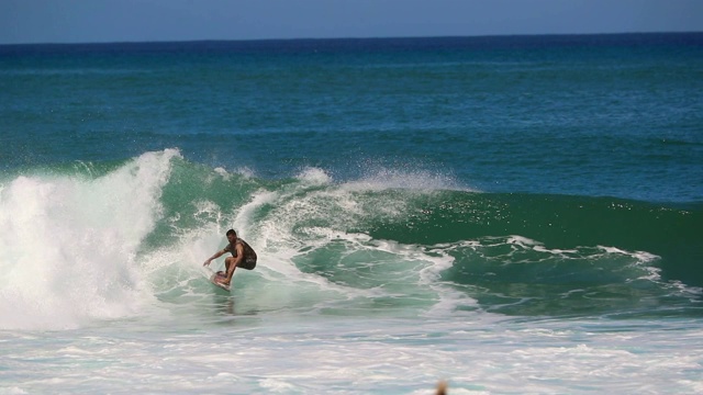 在夏威夷的管道冲浪者抓住一个波浪并慢动作执行一些转弯视频下载