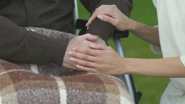 妇女牵着残障男子的手，给予关爱护理视频素材