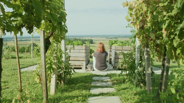 女人在花园里的木箱间休息视频素材