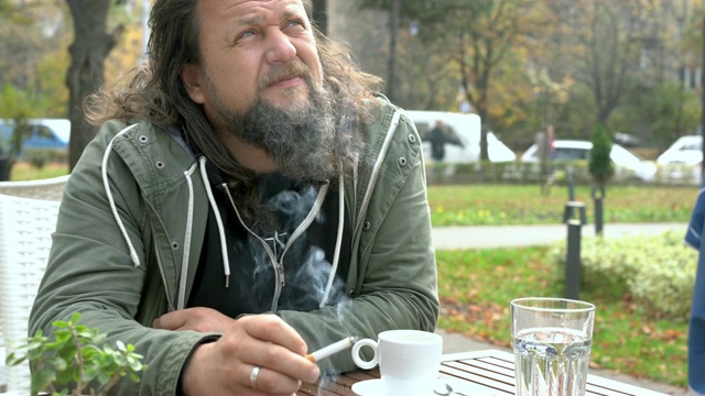 一个悲伤的男人在街上抽烟café视频素材