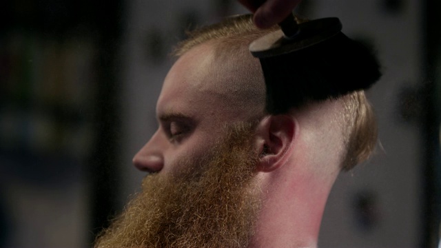 理发师在理发店的慢镜头中给快乐的男顾客抹粉视频下载