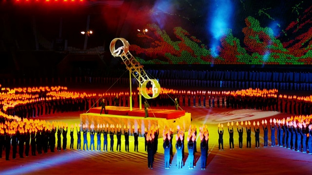 难以置信的死亡之轮表演。在朝鲜平壤举行的大型团体操比赛中，火炬在人群中同步移动。中景镜头视频下载